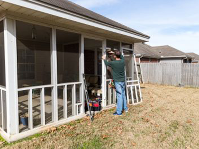 A large tree that has fallen on a residential roof, severely damaging it